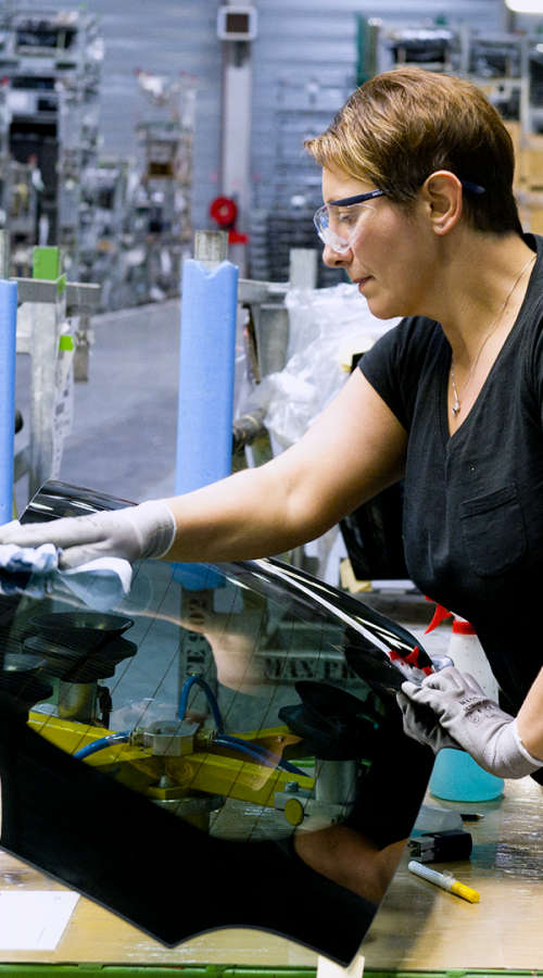 an employee cleans the rear window of a car