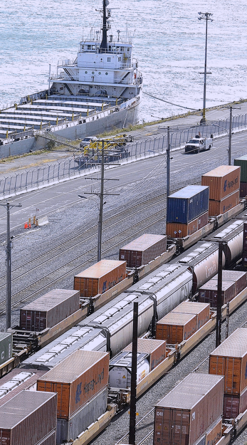 train rail with containers in front of the sea